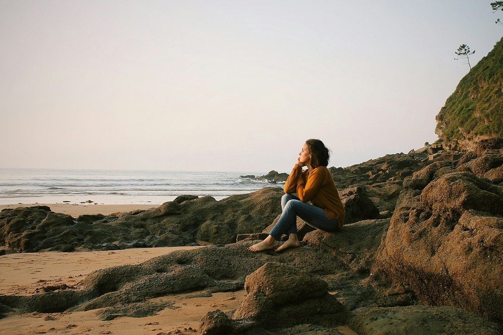 Femme assise près de la mer pendant la journée, photo de Rebe Pascual