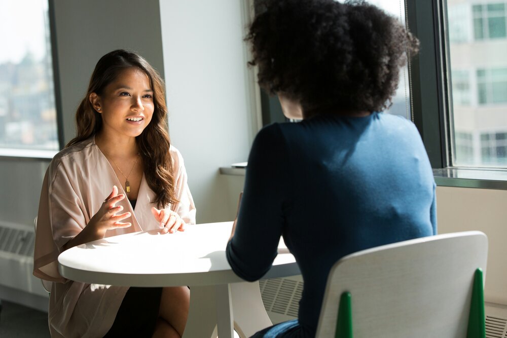 Deux femmes en conversation dans un espace de travail, photo de Christina Morillo